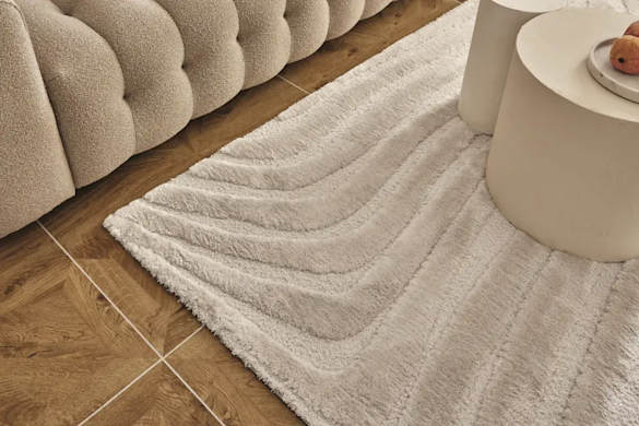 Faut-il placer son tapis devant ou sous le canapé ?